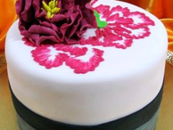 Элегантный торт, украшенный пурпурным цветком и узорами