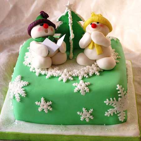 Торт выполнен в виде двух снеговиков, украшен сахарной мастикой