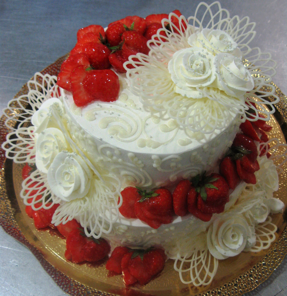 Изысканный торт, украшенный узорами из белого шоколада и клубникой