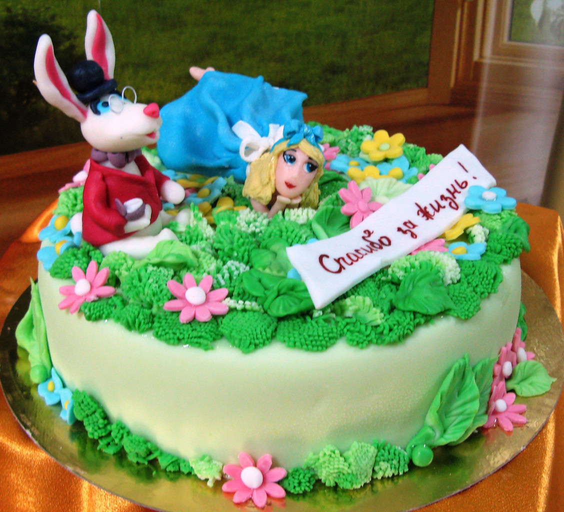 Торт-подарок, украшенный фигурками кролика и девушки на зеленой полянке из мастики