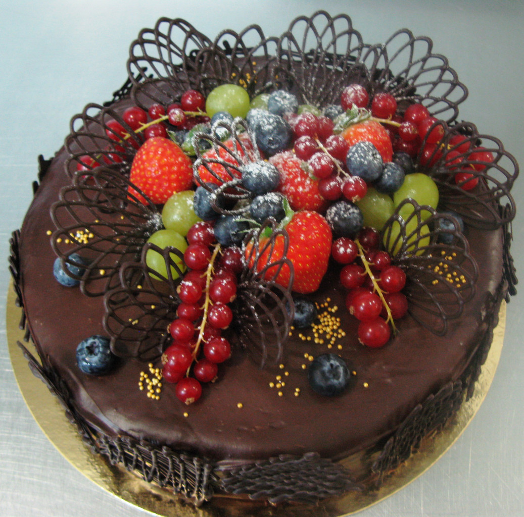 Торт-подарок, украшенный шоколадом и ягодами