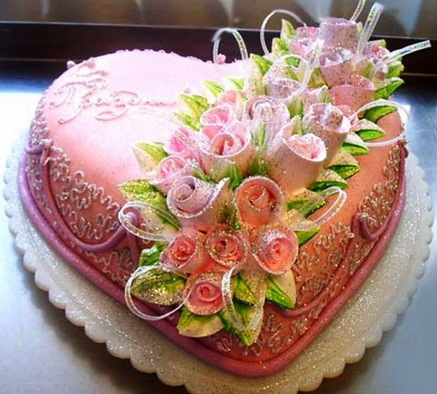 Торт в виде сердца, украшенный букетом цветов из мастики