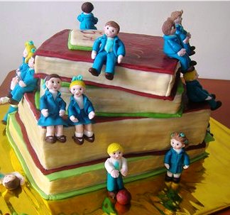 Торт на выпускной Школьники на учебниках, украшенный фигурками из сахарной мастики